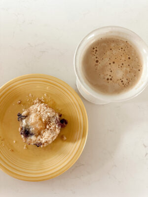 Tray of six streusel-topped sourdough discard blueberry muffins on wood background.