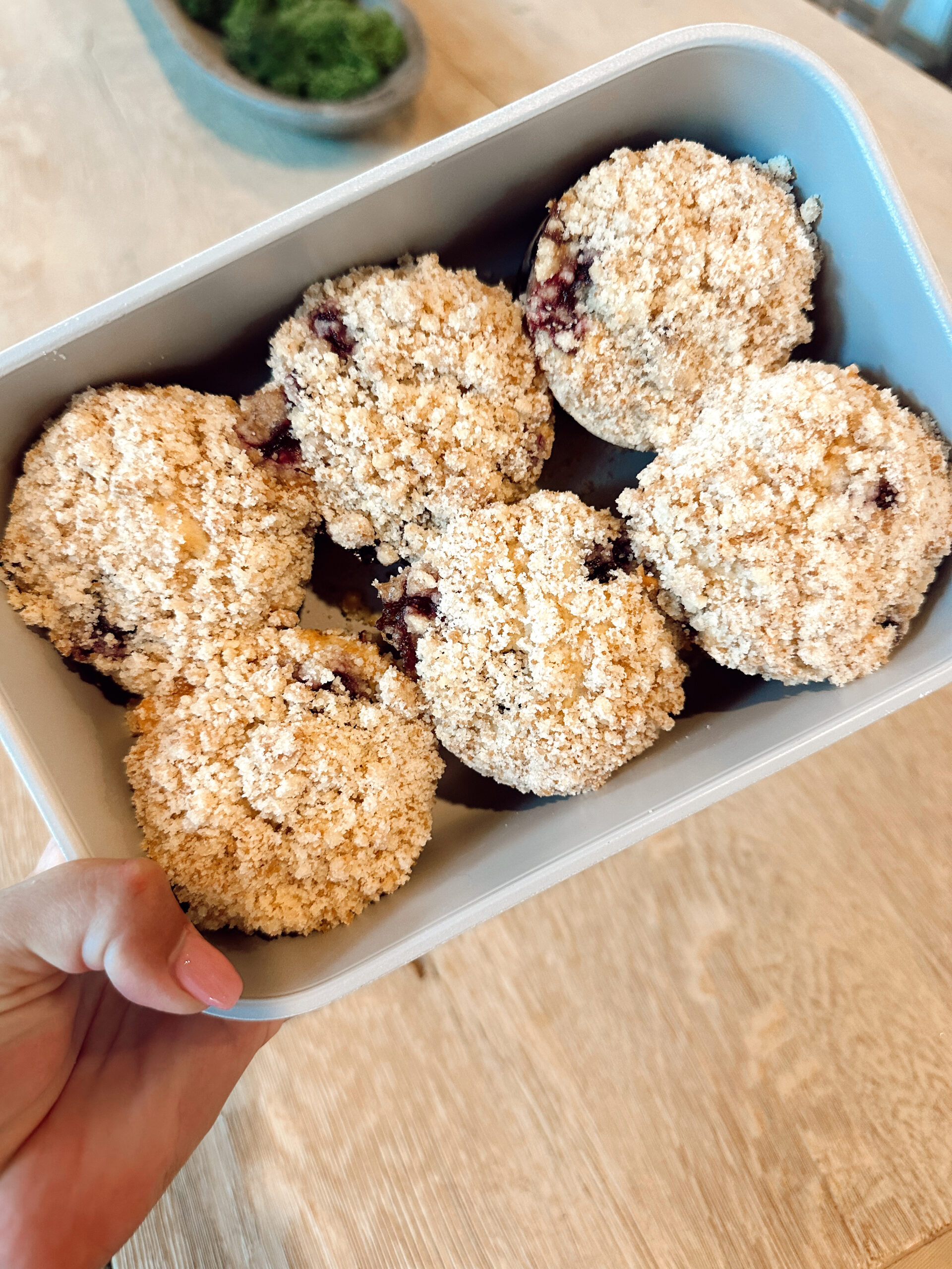 Overhead shot of six sourdough discard blueberry muffins in a baking pan.